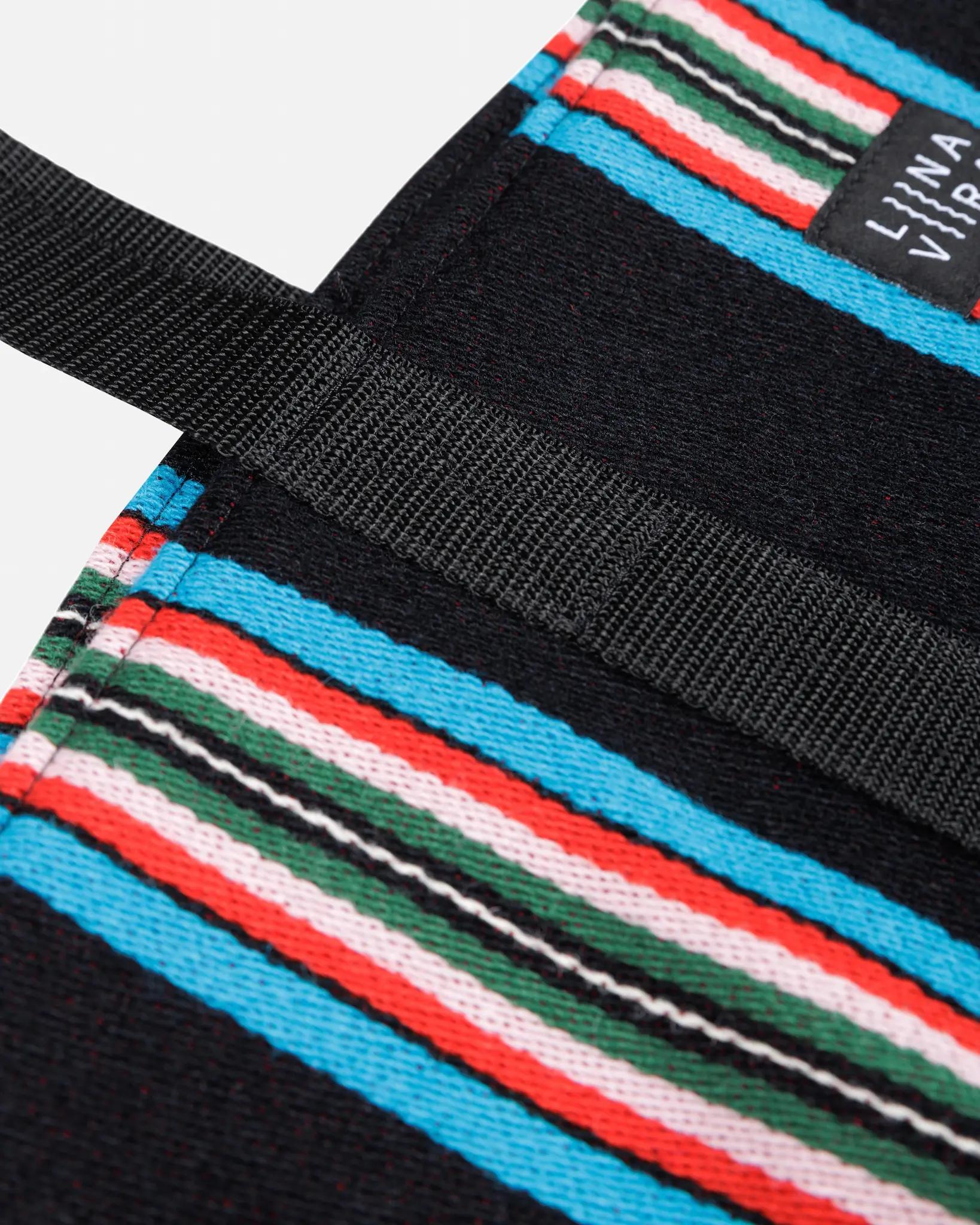 Close-up of a colorful striped bag with a black strap and visible brand name.