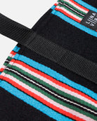Close-up of a colorful striped bag with a black strap and visible brand name.